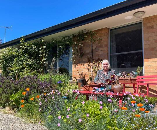 Woman Sitting in her garden at her front porch in the sunshine. Picture